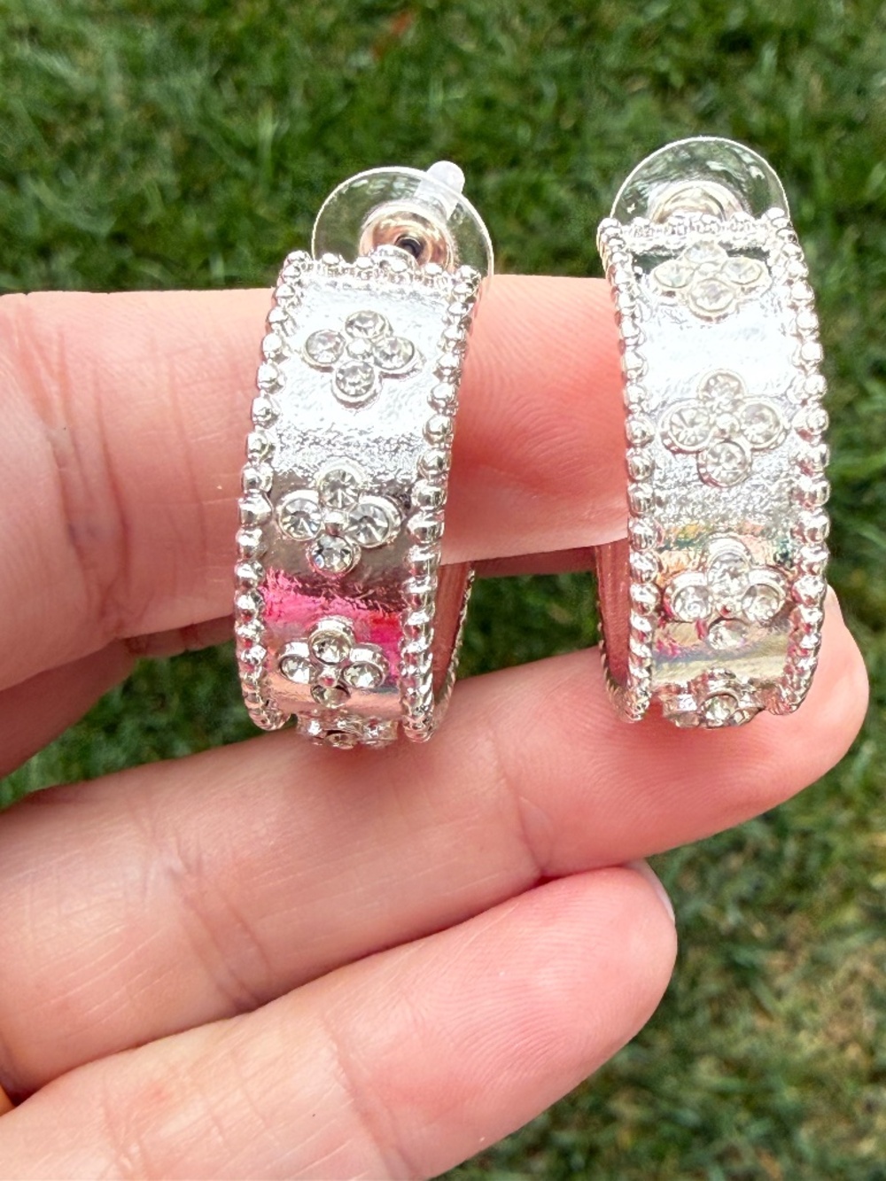 Silver hoop earrings with clover accents